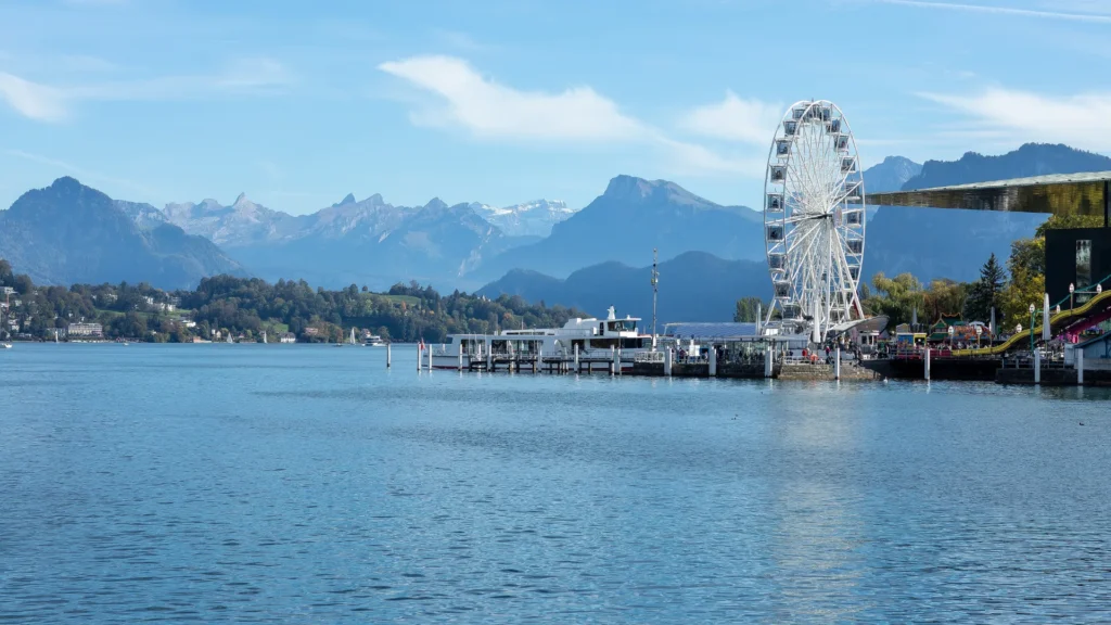 A scenic view of a Swiss lake and mountains with a ferris wheel, representing the balance between discussion and decision-making.