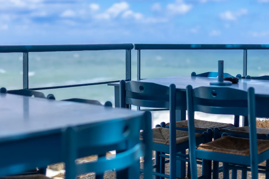 A serene view of blue outdoor tables overlooking the ocean, representing clarity in professional communication.