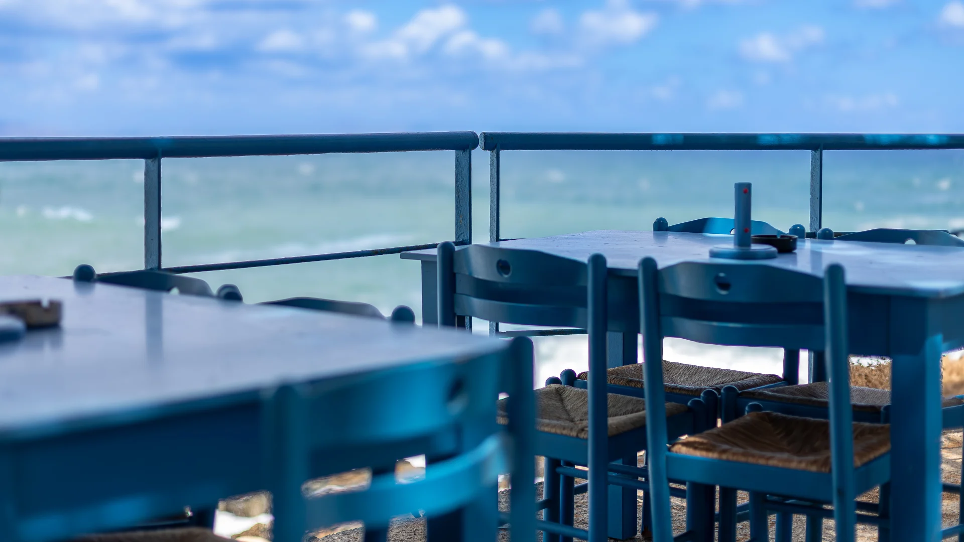 A serene view of blue outdoor tables overlooking the ocean, representing clarity in professional communication.